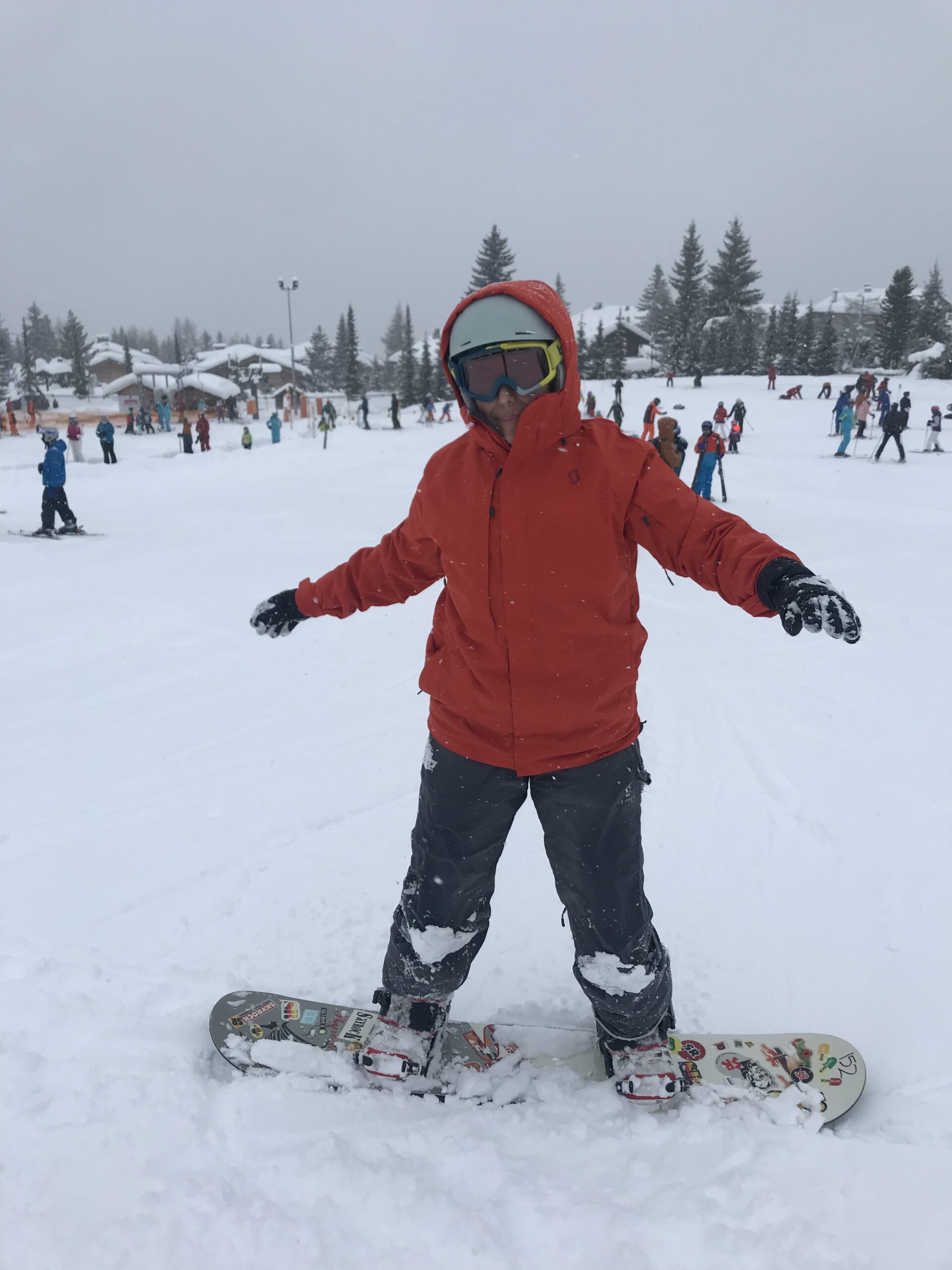 Child learning how to snowboard