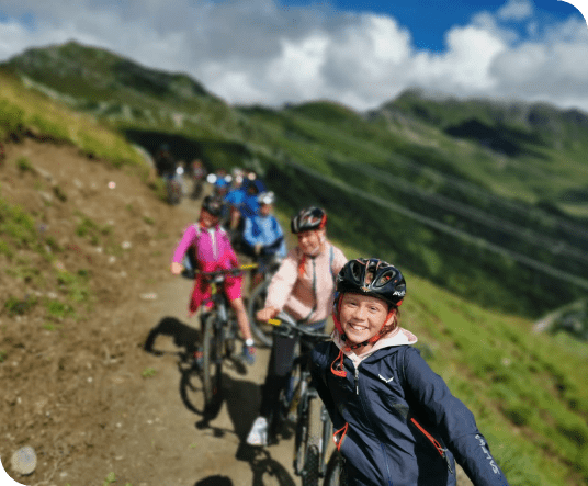 Group of happy kids moutain biking on the Verbier trails in Europe during their 2024 summer camp in Les Elfes International