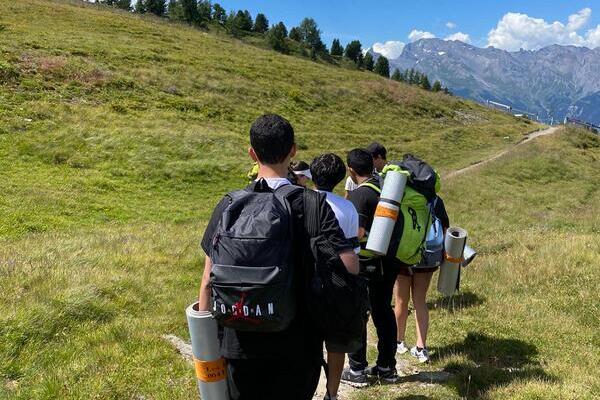 Group of students walking through the Swiss alps to find their campsite during their Duke of Edinburgh's adventurous journey with Les Elfes International summer camp 2024
