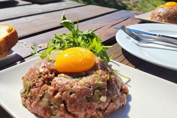 Beef tartare cooked by Les Elfes International's private cehfs and served outside with egg yolk on top and roquette salad as decoration